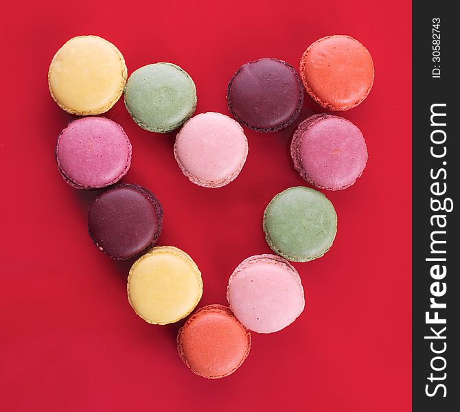 Picture of different colored macaroons on a red background