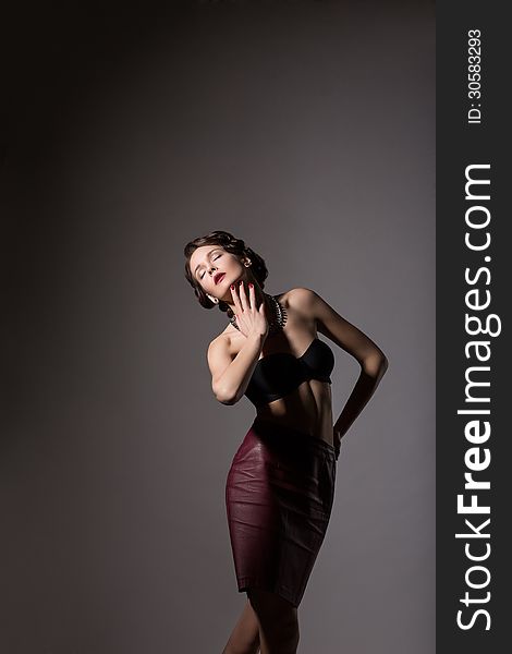 Femininity. Elegant Daydreaming Woman posing in Studio over Grey Background