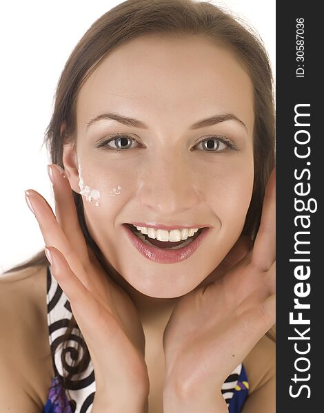 Stock photo portrait of beautiful young woman touching her face with cream, isolated