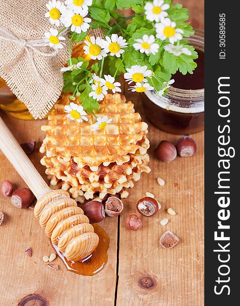 Waffles with honey and nuts on a wooden surface