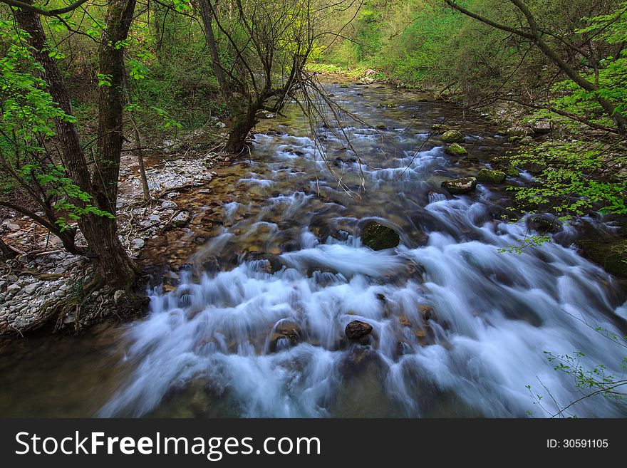 Mountain stream and waterfalls in the forest in spring