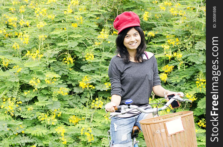 Portrait of an happy smiling girl riding a bicycle in the park.Looking at camera.