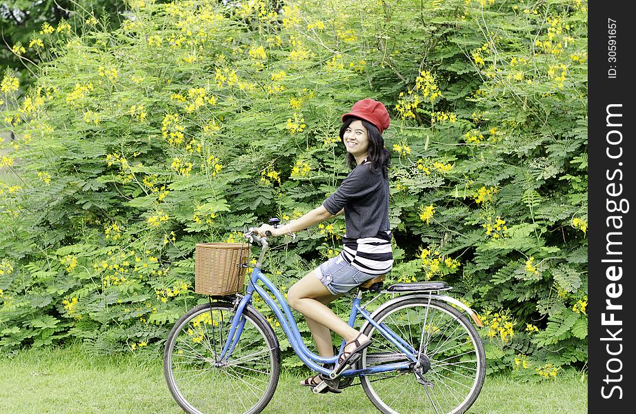 Portrait of an happy smiling girl riding a bicycle in the park