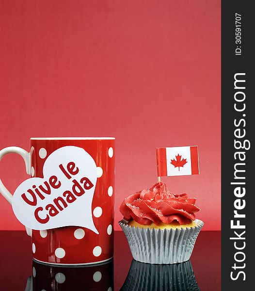 Red and white theme Canadian cupcake with maple leaf flag and red polka dot coffe mug with Happy Canada Day, Vive Le Canada, or copy space for your text here. Vertical with copy space.