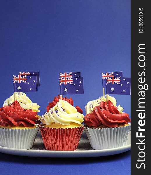 Australian theme red, white and blue cupcakes with national flag for Australia Day, Anzac Day or national holiday against a blue background. Vertical with copy space for your text here. Australian theme red, white and blue cupcakes with national flag for Australia Day, Anzac Day or national holiday against a blue background. Vertical with copy space for your text here.