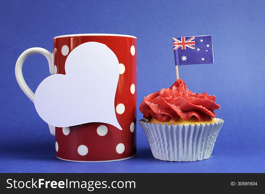 Australian theme red, white and blue cupcake with national flag and red polka dot coffee mug and white heart tag for your text here, for Australia Day, Anzac Day or national holiday against a blue background. Australian theme red, white and blue cupcake with national flag and red polka dot coffee mug and white heart tag for your text here, for Australia Day, Anzac Day or national holiday against a blue background.