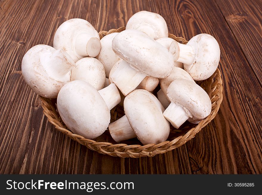 Mushrooms in a basket on a wooden background