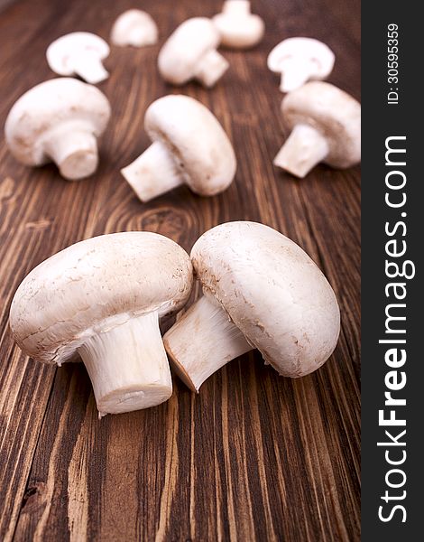 Champignons on a brown wooden background, selective focus