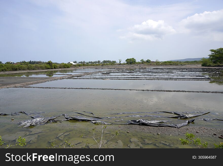 View Of Salt Fields Submerged In Water During A Clear Sky During The Day