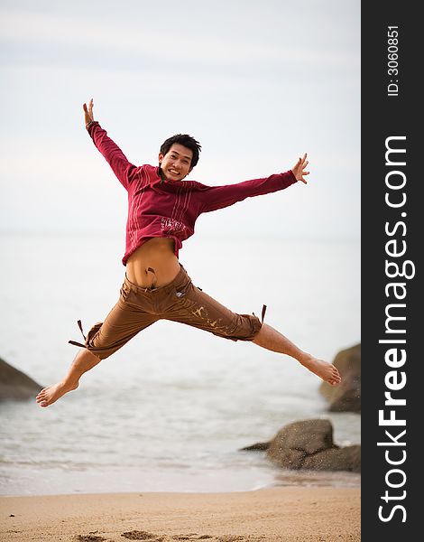 A young man jumping at the beach high and wide. A young man jumping at the beach high and wide