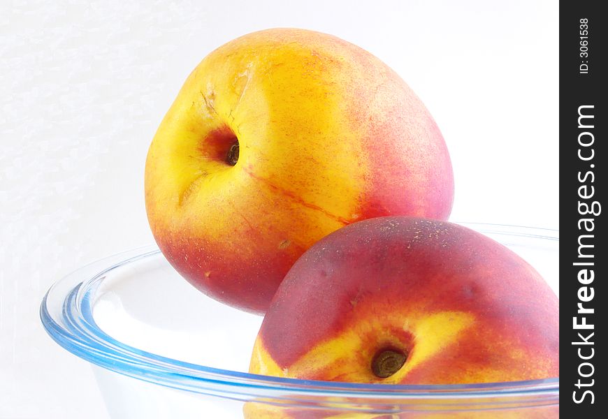 Two peach lie in a glass vases. Isolated on a white background. Two peach lie in a glass vases. Isolated on a white background.