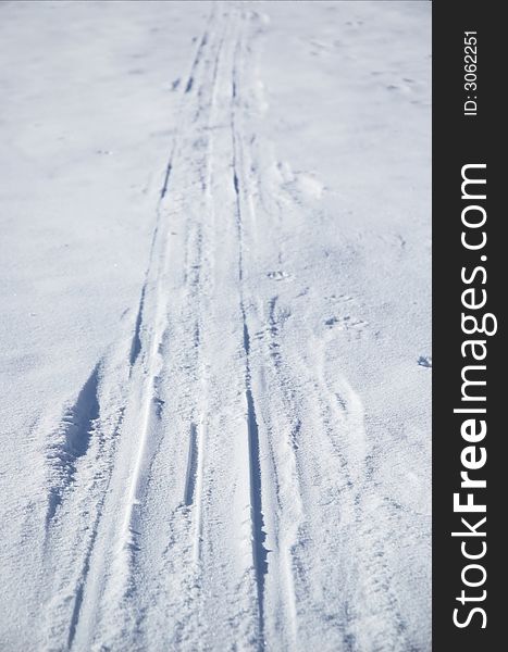 Cross country ski tracks up a snow covered hill.