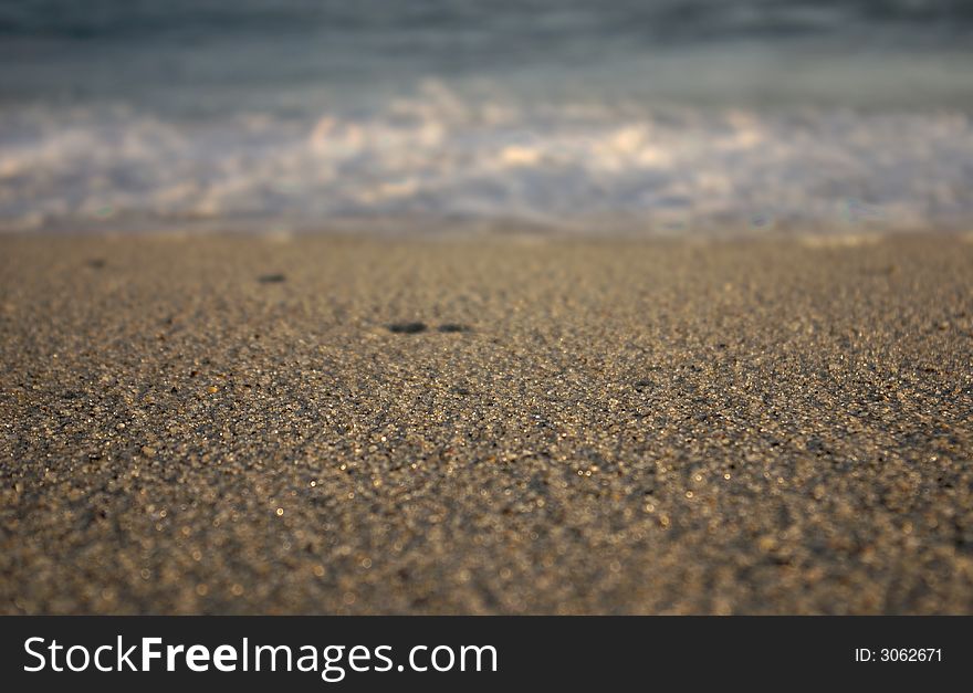 Waves breaking on Nantucket with water droplets spewing out and the focus on the sand in front. Waves breaking on Nantucket with water droplets spewing out and the focus on the sand in front