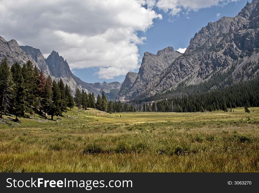 In a valley surrounded by mountains on all sides on a clear summer day in the Bridger Teton Forest, Wyoming. In a valley surrounded by mountains on all sides on a clear summer day in the Bridger Teton Forest, Wyoming.