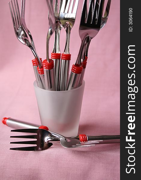 Many forks in a small frosted glass