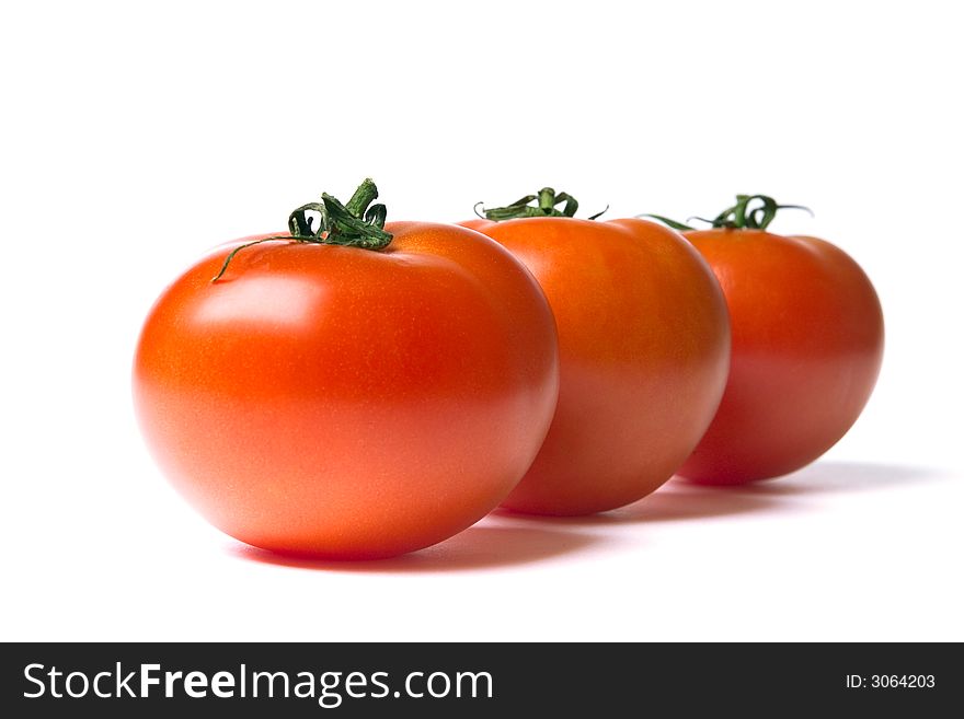 Three ripe red tomatoes on a white background