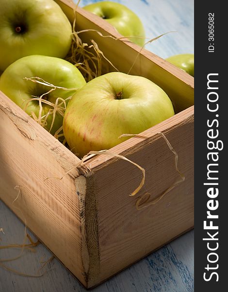Green apples in the  wooden box