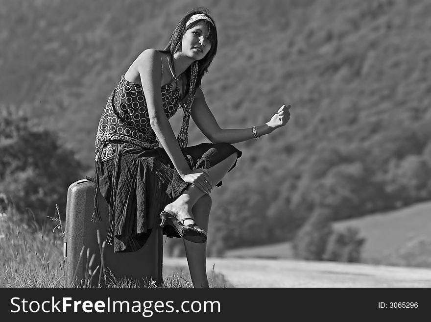 Woman on a mountain road making of hitch-hiking. Woman on a mountain road making of hitch-hiking