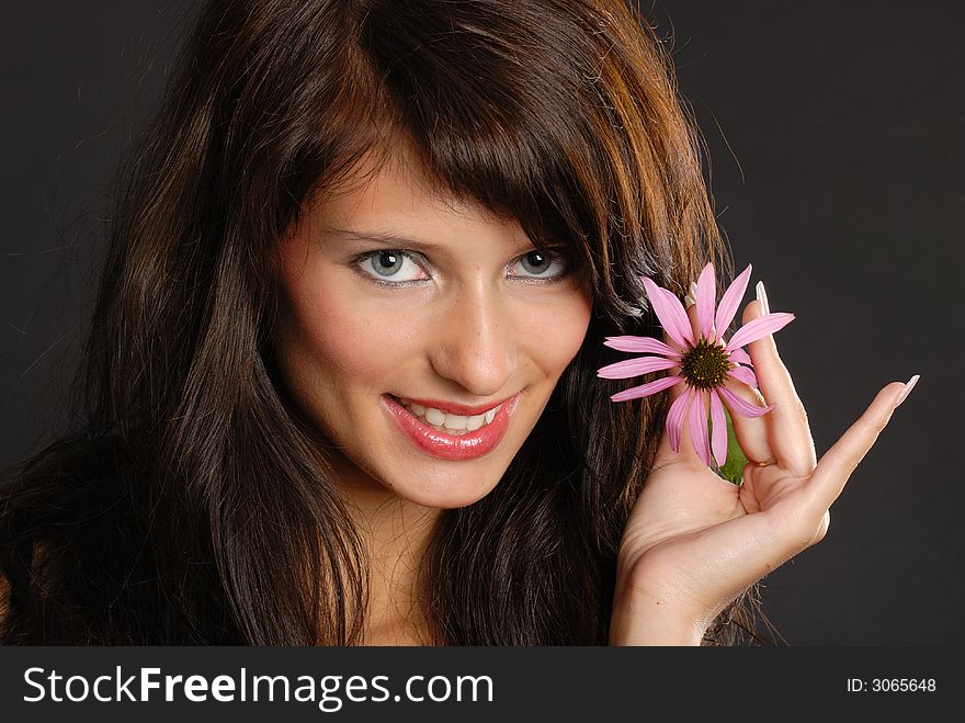 Girl with echinacea-flower on black background