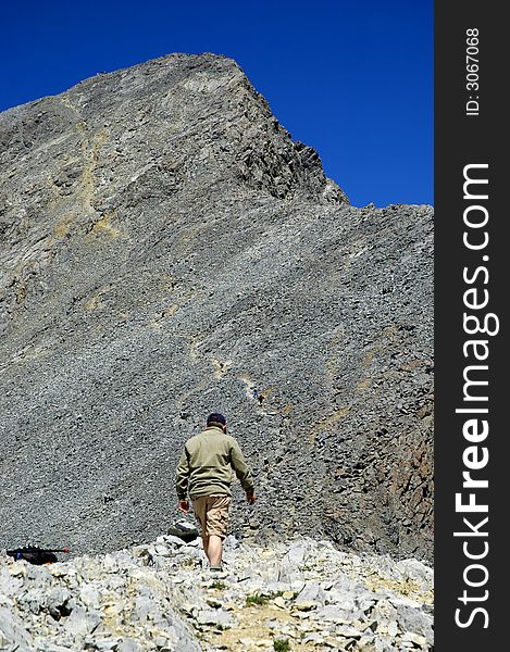 Single person climbing along rocky ridge on a trail. Single person climbing along rocky ridge on a trail