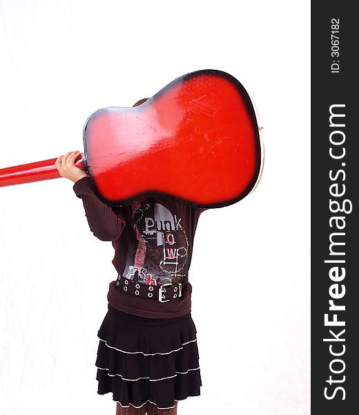 Brunette little girl and her red guitar