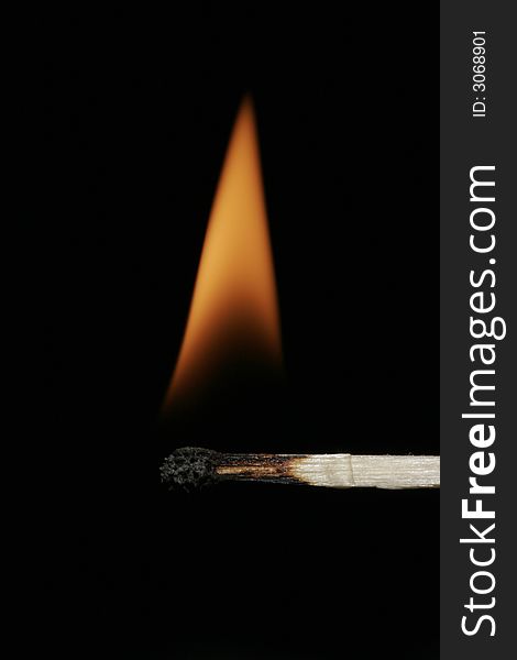 Burning Flame On A Single Matchstick On A Black Background. Burning Flame On A Single Matchstick On A Black Background