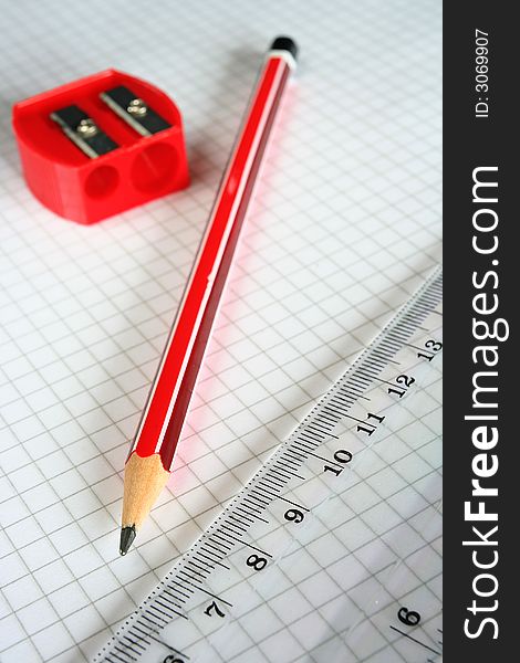 Pencil,sharpener and ruler on grid paper. Pencil,sharpener and ruler on grid paper