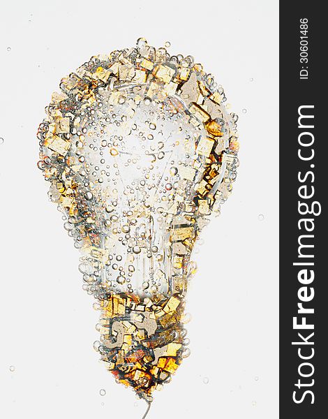 An electric light bulb composed with a closeup picture of small crystals of light brown and yellowish color. An electric light bulb composed with a closeup picture of small crystals of light brown and yellowish color