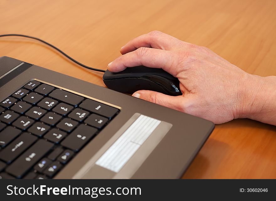 Man's hand with a black computer mouse. Man's hand with a black computer mouse