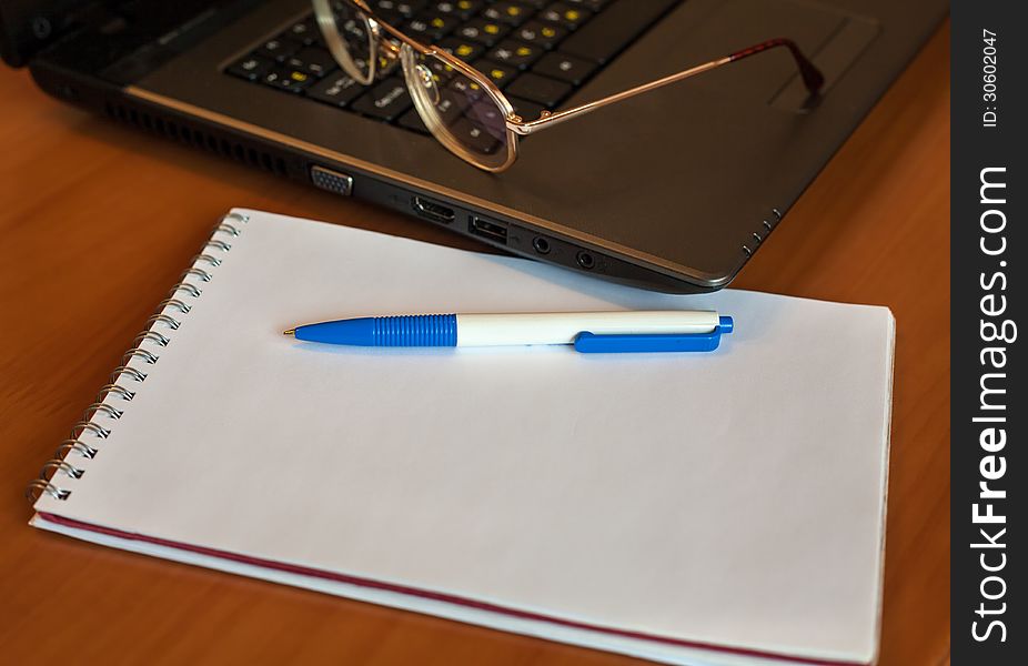 Pen With Notebook And Glasses Near Laptop