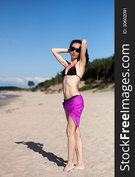 Young beautiful woman on the beach on sunny summer day
