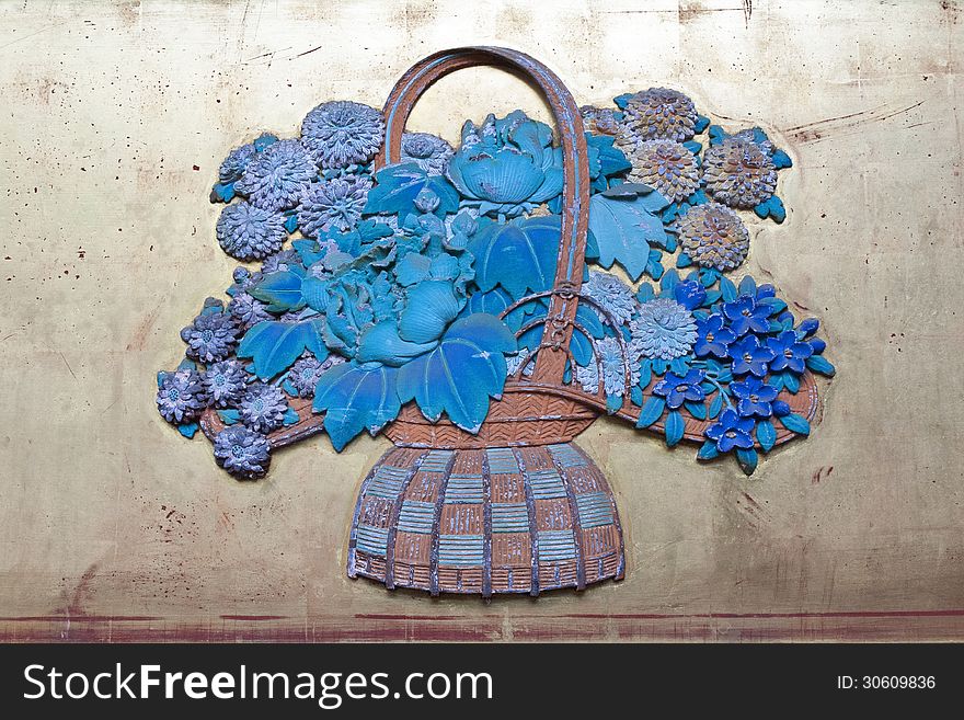 Wooden carving of blue flowers bouquet on the wall of ancient Japanese Temple
