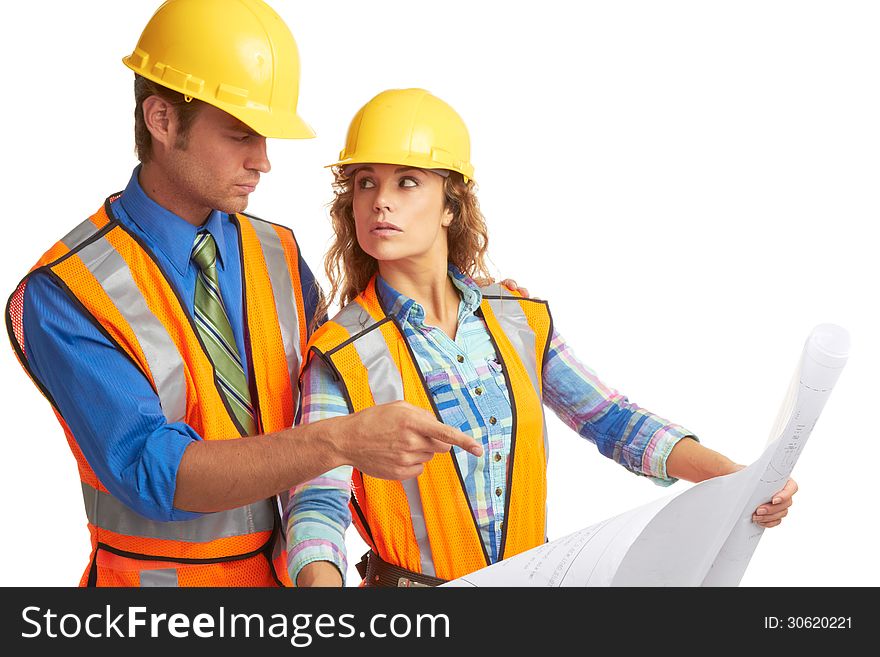 Attractive male and female construction workers looking at blueprints isolated on white.