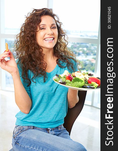 Close-up of a beautiful happy female eating a salad