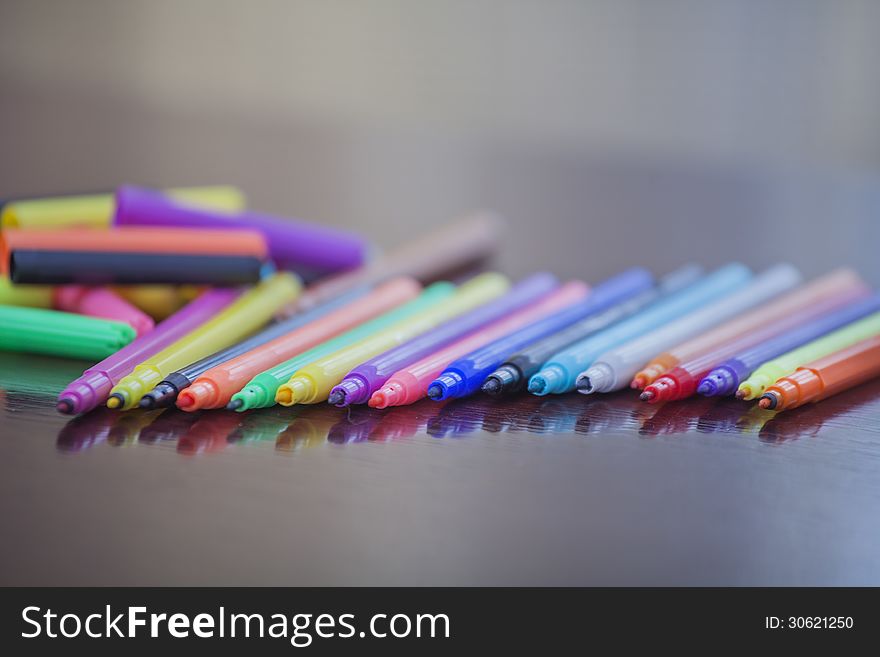 Colored markers lie in a row on the table