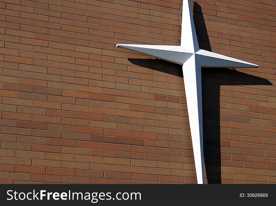 White Cross on outdoor Red Brick Wall building siding. White Cross on outdoor Red Brick Wall building siding