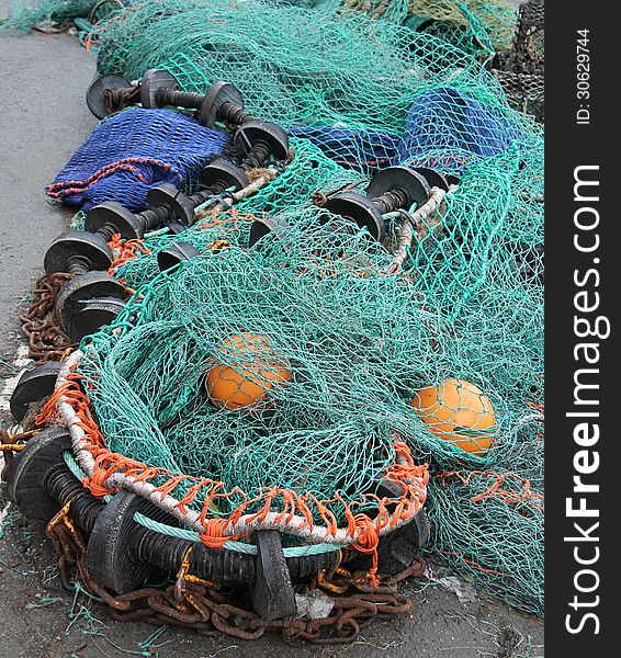 Some Fishing Nets and Floats Laying on a Quayside. Some Fishing Nets and Floats Laying on a Quayside.