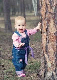Happy Baby Girl Stands On Legs Near A Tree In The Park Outdoors Stock Photo Happy Baby Girl Stands On Legs Near A Tree In The Park Outdoors Stock Photo