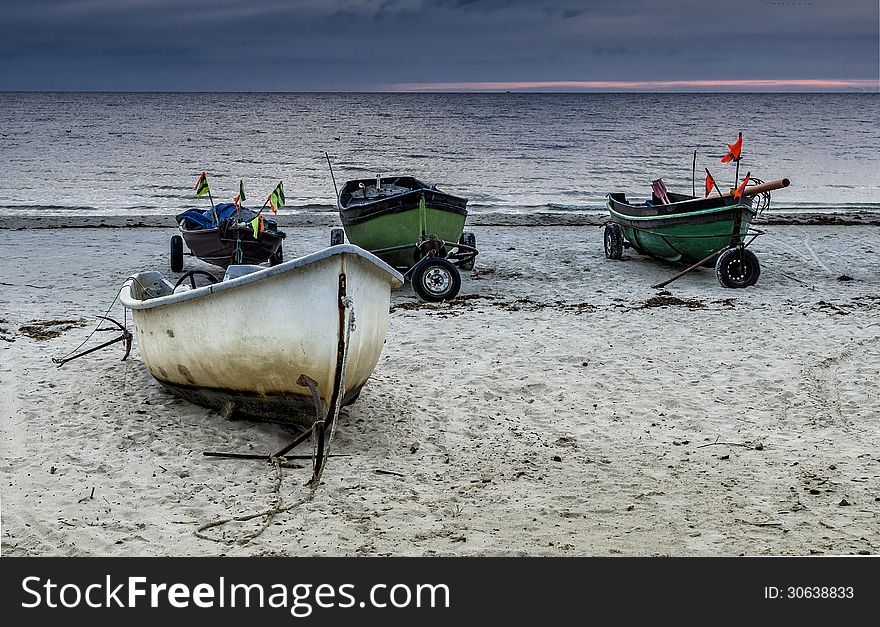 The fishing boats were photographed at the early morning on the beach of Baltic Sea, Latvia, Europe. The fishing boats were photographed at the early morning on the beach of Baltic Sea, Latvia, Europe