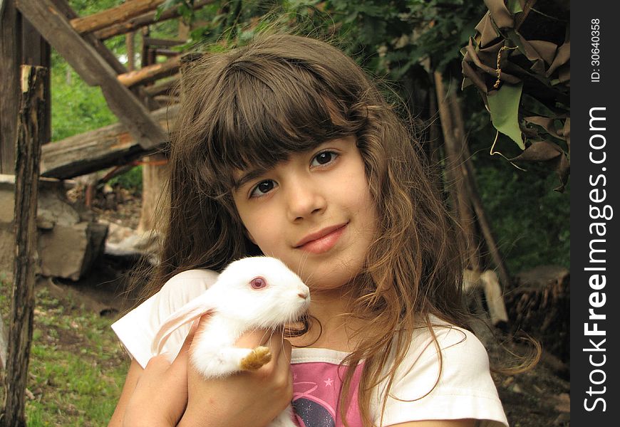 Portrait of happy little girl with adorable white rabbit. Portrait of happy little girl with adorable white rabbit