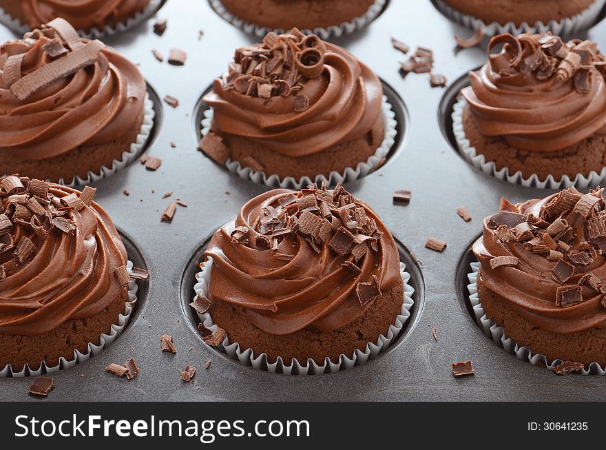 Chocolate cupcakes with swirl frosting in baking pan
