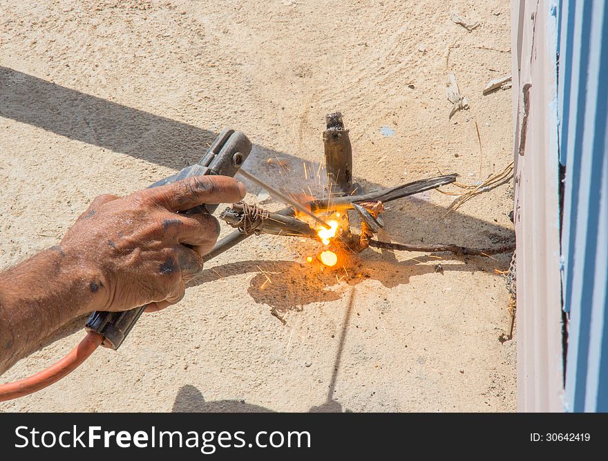 Welder works sparkle cutting metal