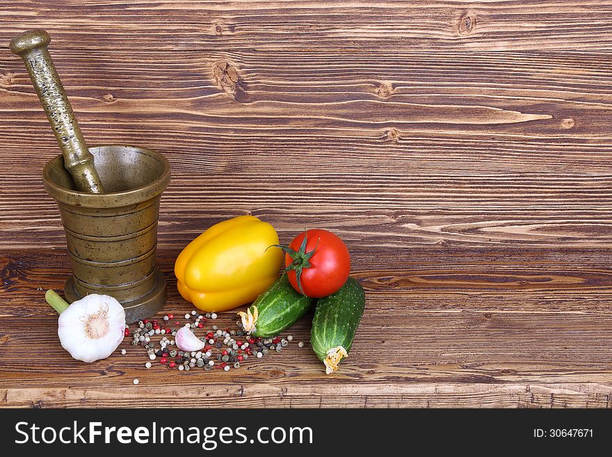 Set of vegetables, the mortar and pestle on wooden background