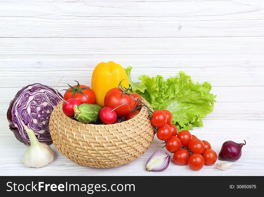 Multi-colored vegetables on a light wooden background. Multi-colored vegetables on a light wooden background