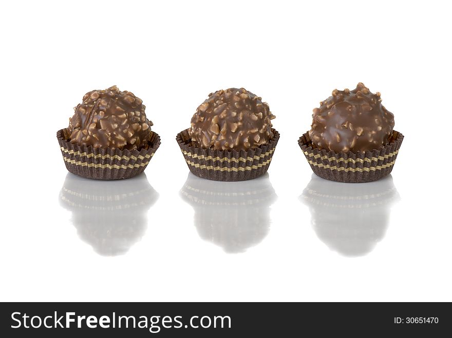 Three chocolate candy with nuts on a white background