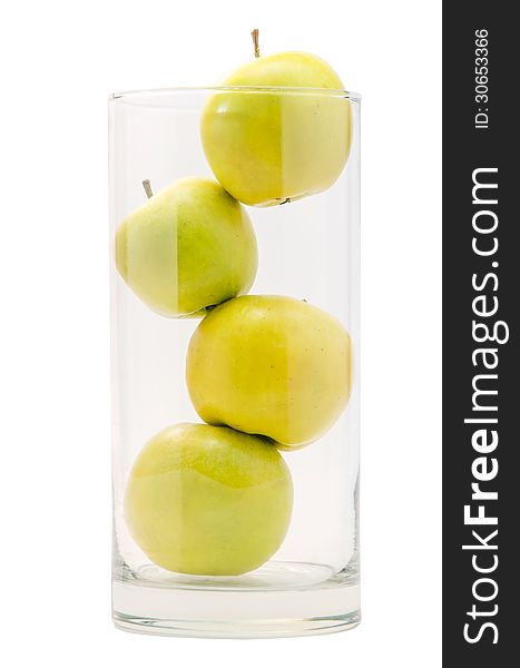 Four yellow apples in big glass on white background isolated.