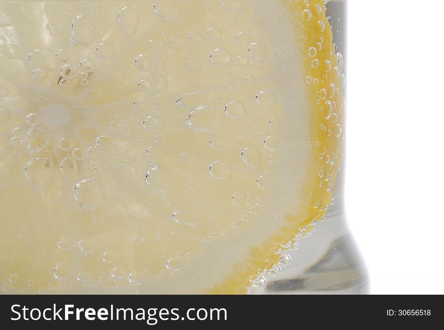 Bubbles on a lemon slice in soda water. Bubbles on a lemon slice in soda water