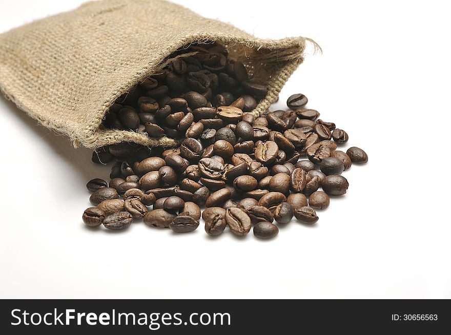 Coffee beans in burlap sack shot over white background