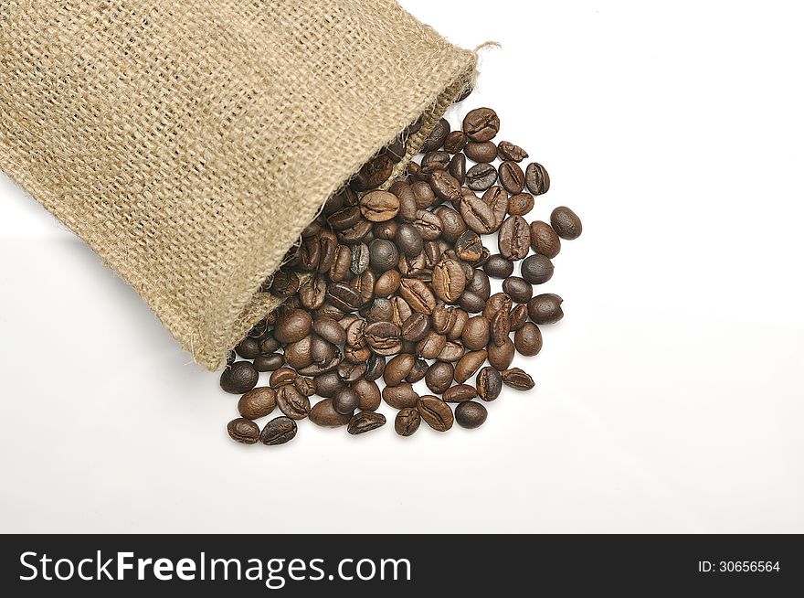 Coffee beans in burlap sack shot over white background