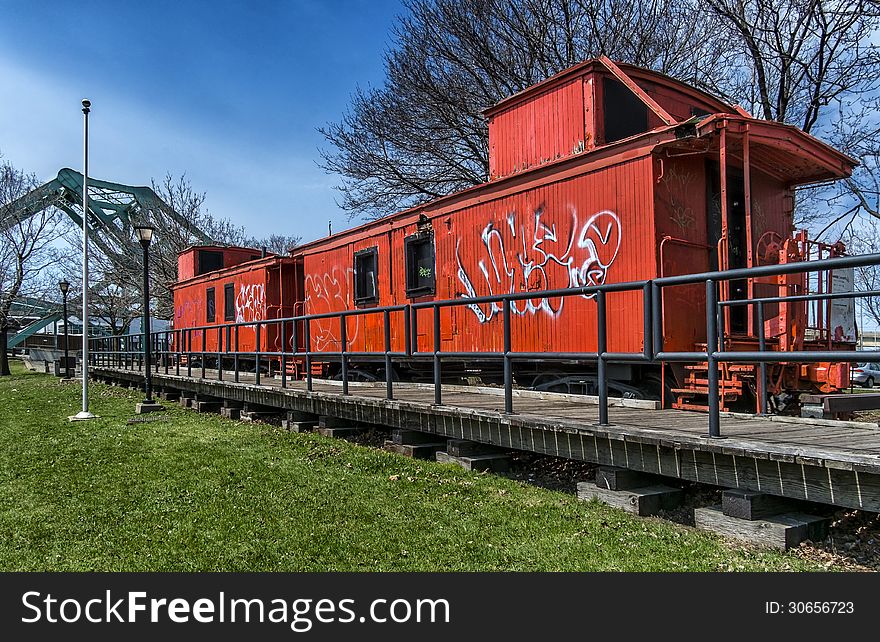 Old orange train with a steel bridge in the background